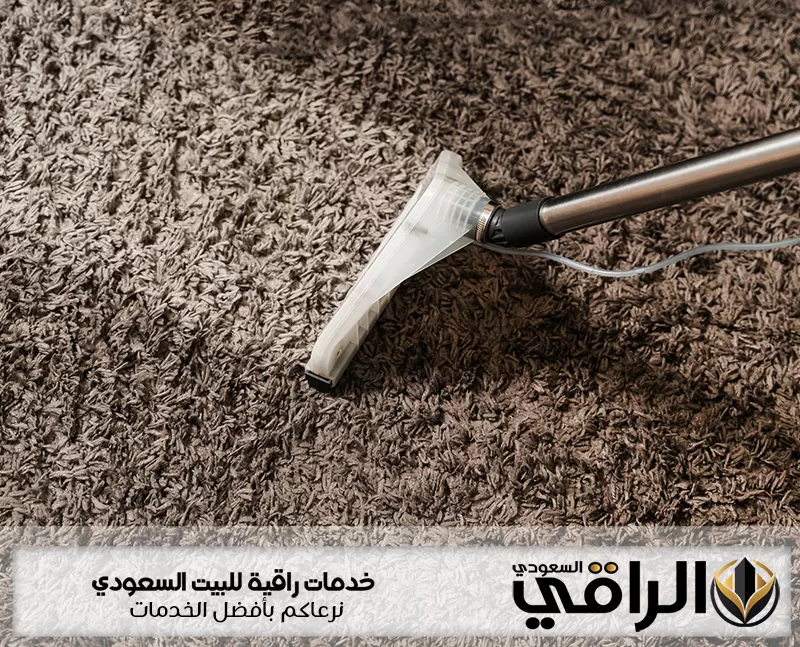شركة تنظيف مفروشات بتبوك تنظف سجادة بنية كثيفة الوبر بفوهة شفط شفافة ويظهر شعار الراقي السعودي تحتها